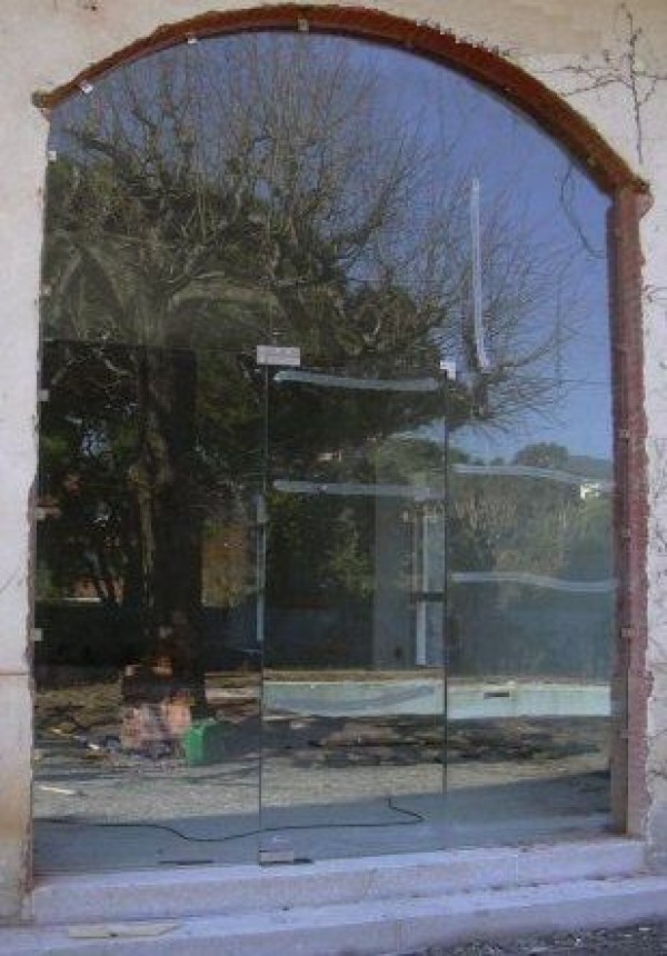 Instal·lació securit en finca rústica composta per vidres temperats de gran resistència per a l'entrada d'unes oficines que volien un disseny una mica fora del normal.